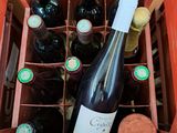 plusieurs bouteilles de vin dans une caisse rouge avec des bouchons