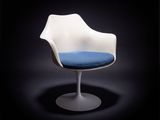 une chaise blanche avec une assise bleue sur fond noir