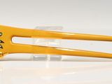 a yellow hair clip that has a gold flower on it