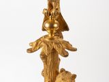 a gold statue of a bird and a bear on top of a tree