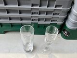 deux verres vides posés sur une table à côté d'un porte-verres contenant des verres vides