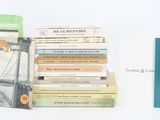 several books are stacked on top of each other on a white surface