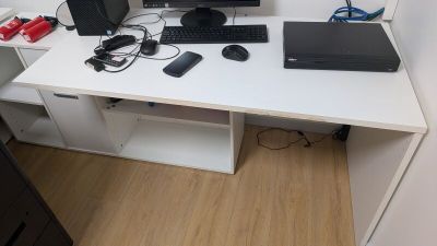 un bureau blanc sur lequel se trouvent un ordinateur de bureau et un ordinateur portable