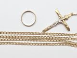 chaîne en or avec une croix et une bague sur fond blanc