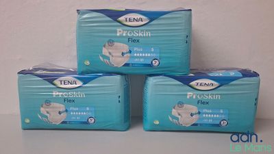 trois paquets de couches Tenna Premium Flexx posés sur une table