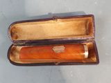 a brown case that has a pen in it on a table