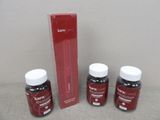 three bottles of red liquid sitting next to a red box