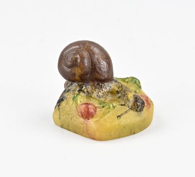 a small snail sitting on top of a piece of food