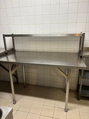 a large stainless steel table in the kitchen