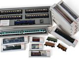 de nombreux petits trains miniatures dans une boîte posée sur une surface blanche