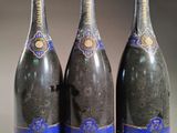 trois bouteilles de champagne posées les unes à côté des autres sur une table