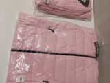 Deux sacs de vêtements roses sont posés sur une table blanche