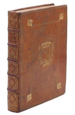 un vieux livre relié en cuir, orné de dorures et d'un blason sur la couverture