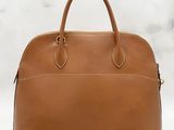 a brown leather handbag on a white background