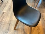 une chaise noire posée au milieu d'un parquet