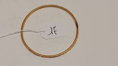une photo d'un bracelet en or auquel est attachée une étiquette