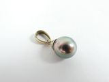 a close up of a pearl pendant on a white surface