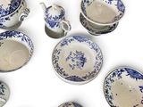 a group of blue and white dishes and cups on a white surface