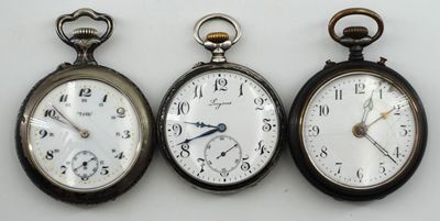 trois types différents de montres de poche sont présentés sur une surface blanche