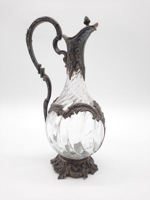 un vase ancien en argent et en verre, muni d'une anse, sur fond blanc