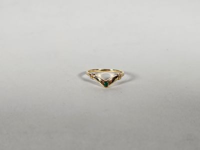 une bague en or avec une pierre verte au centre
