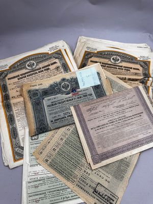 plusieurs anciens certificats papier sont empilés les uns sur les autres