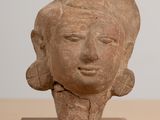 statue représentant la tête d'une femme, posée sur un socle en bois