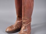 une paire de bottes de cow-boy en cuir marron sur fond gris