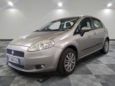 la petite voiture argentée est garée sur un carrelage à carreaux