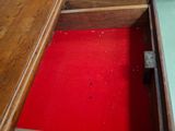a wooden desk with a red drawer underneath it