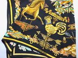 a close up of a black and gold scarf with a horse on it