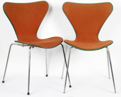 pair of orange chairs with chrome legs against a white background
