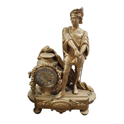 une statue en or représentant un homme avec une horloge posée sur une table