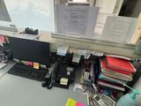 a desk with a computer, keyboard, mouse, and papers on it