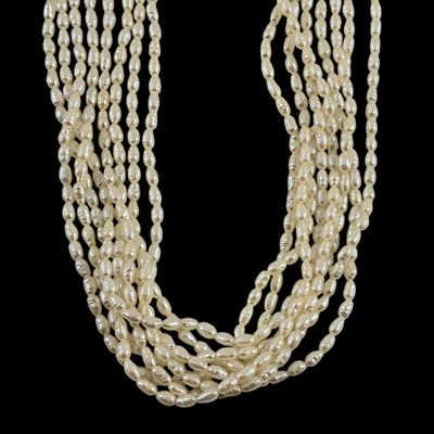 un collier de perles avec un fermoir en or sur fond noir