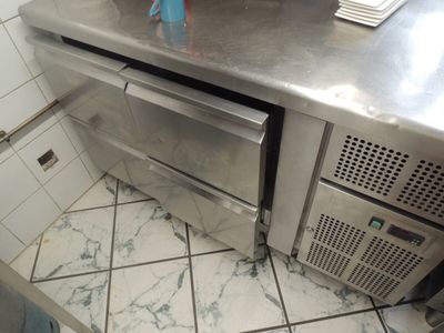 stainless steel counter top in a commercial kitchen with a dishwasher and dishwasher