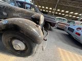 many old cars parked in a garage next to each other