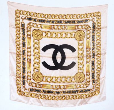 a chanel scarf with gold chains and a black and white logo