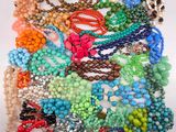 assorted beaded necklaces and bracelets on a white surface