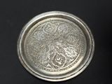 an antique silver plate with a floral design on it