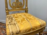 an image of a chair with a gold upholstered seat on a blue rug