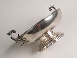 a silver plate with a handle on it on a table