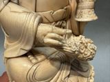 une statue représentant un homme tenant une cloche à la main