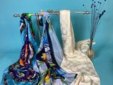 three scarves hanging on a rack on a blue background