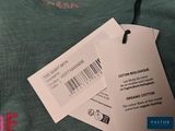 a green shirt with a barcode on it and a tag attached to it