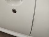 a white car that has a hole in the side of it