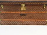 a brown and black checkered trunk sitting on a white surface