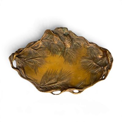un plateau en or orné d'un motif de pin