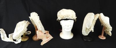 trois chapeaux et une paire de chaussures sont posés sur une table