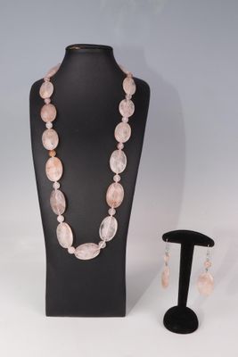 un gros plan sur un ensemble composé d'un collier et de boucles d'oreilles, présenté sur un mannequin